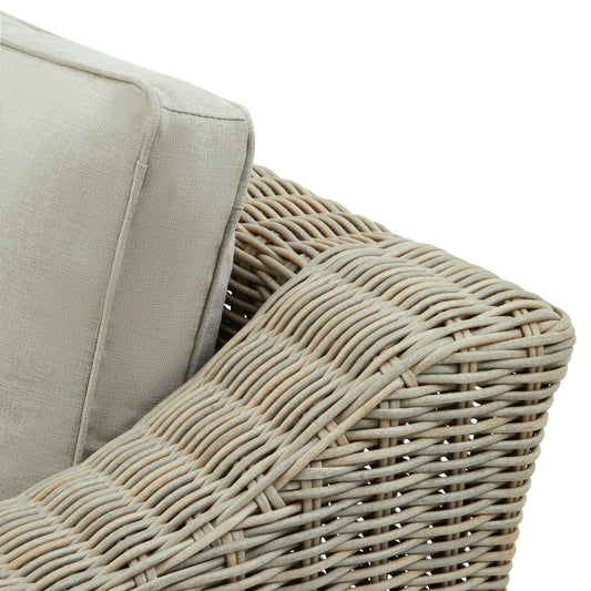 Close-up of a wicker chair with beige cushion on a white background