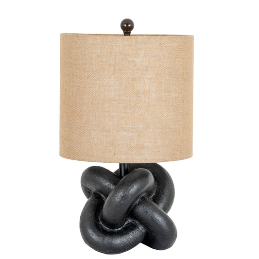 Table lamp with a knot design base and beige lampshade on a white background