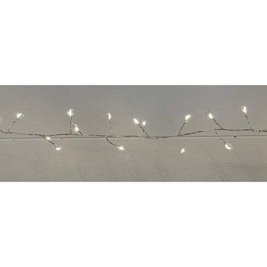 String of small lights on a branch against a plain background