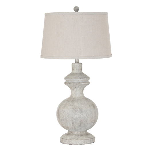 Table lamp with a textured base and white shade on a white background