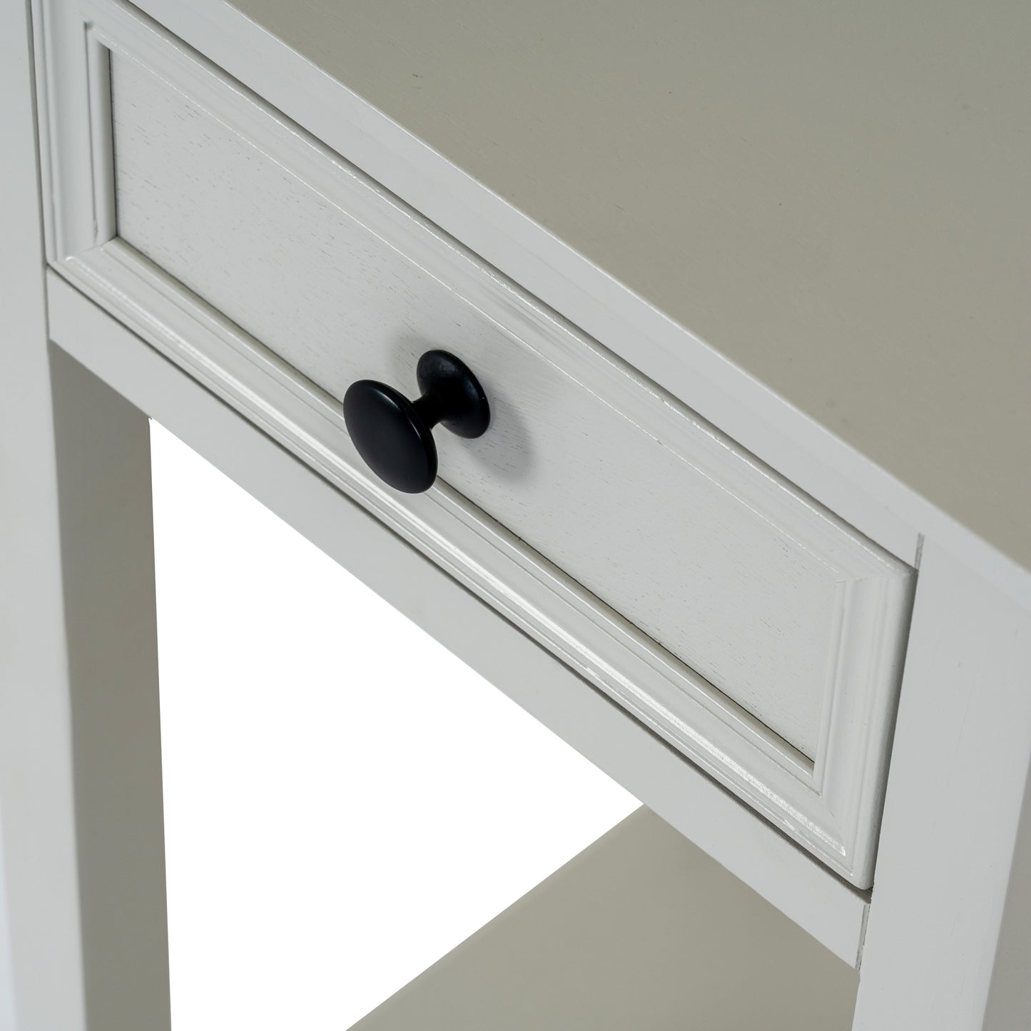 White cabinet with a black knob on a neutral background