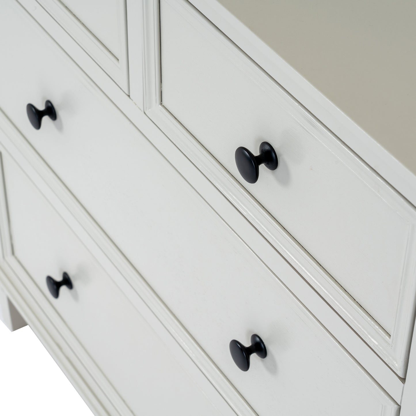 White dresser with black knobs on a neutral background