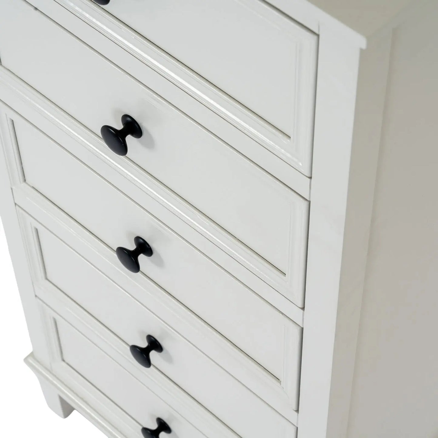 White dresser with black knobs on a plain background