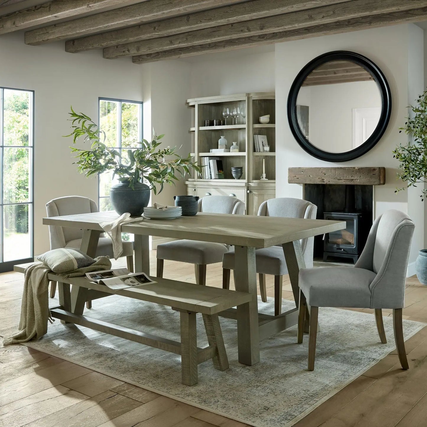 Dining room with wooden table, chairs, and a fireplace.