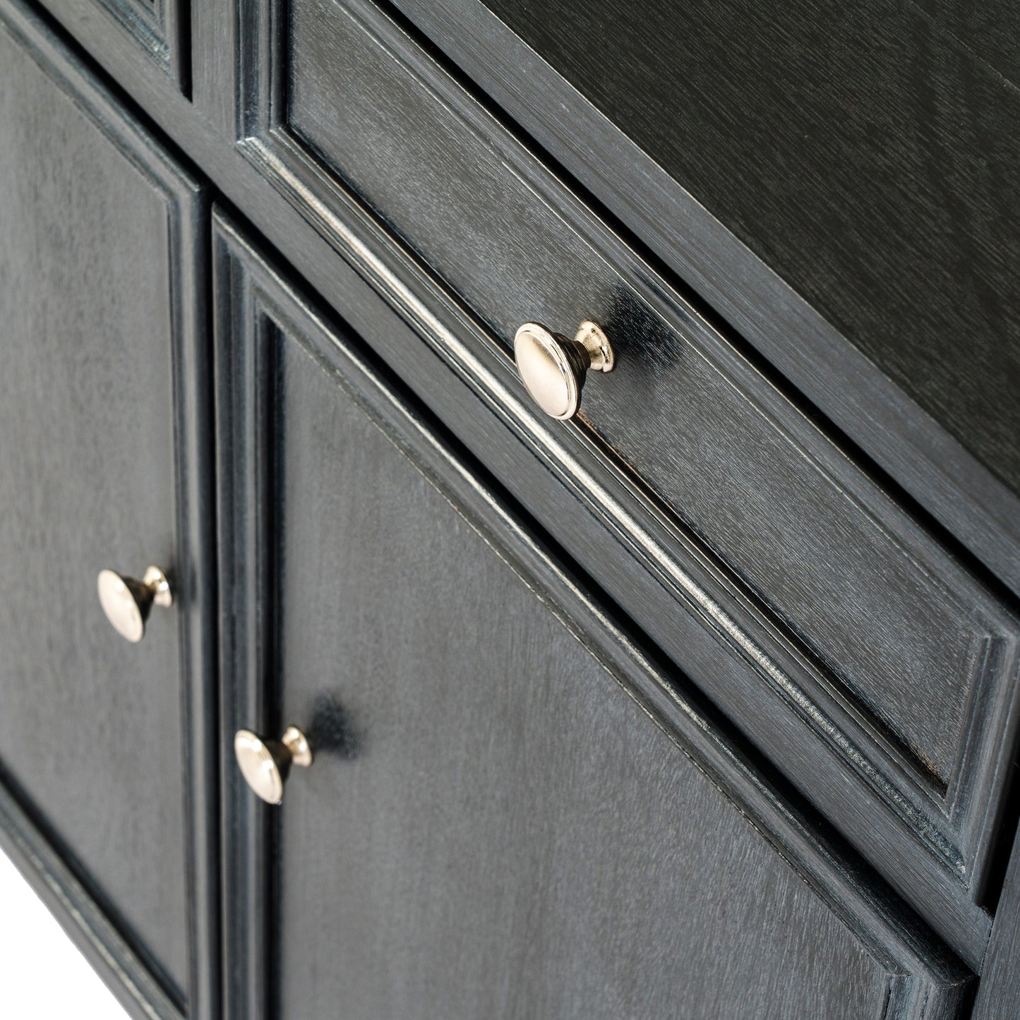 Close-up of a black cabinet with gold knobs