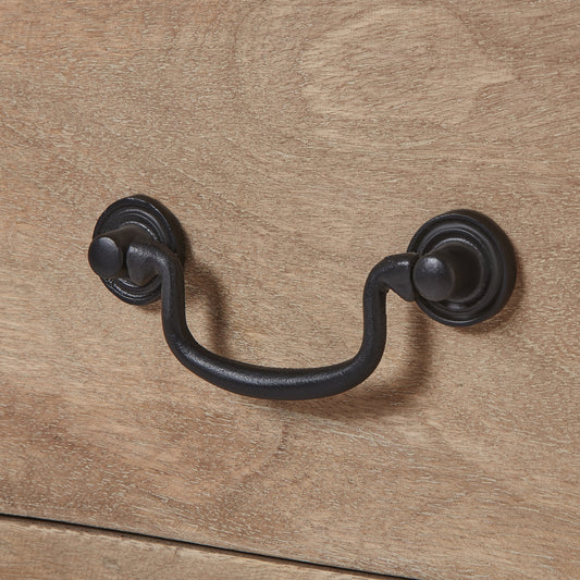 Black metal handle on a wooden surface