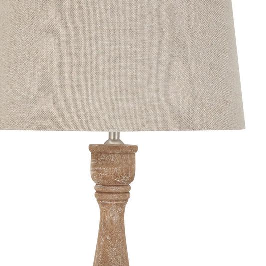Lamp with a beige fabric shade and wooden base on a white background