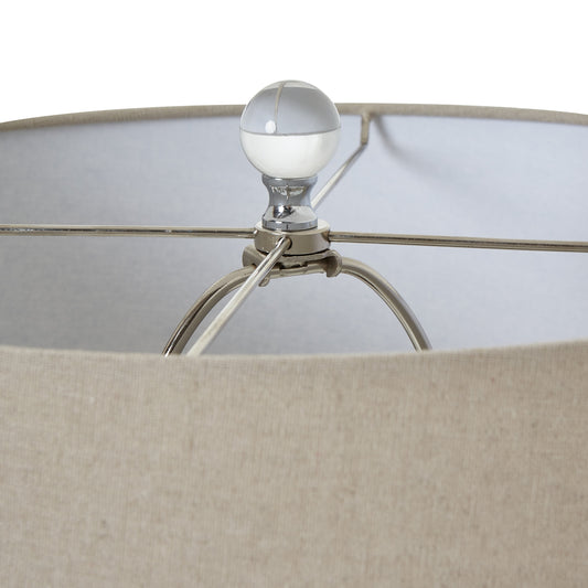 Close-up of a lamp with a beige shade and metallic base.