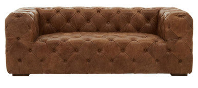 Brown leather sofa with tufted backrest and armrests on a white background