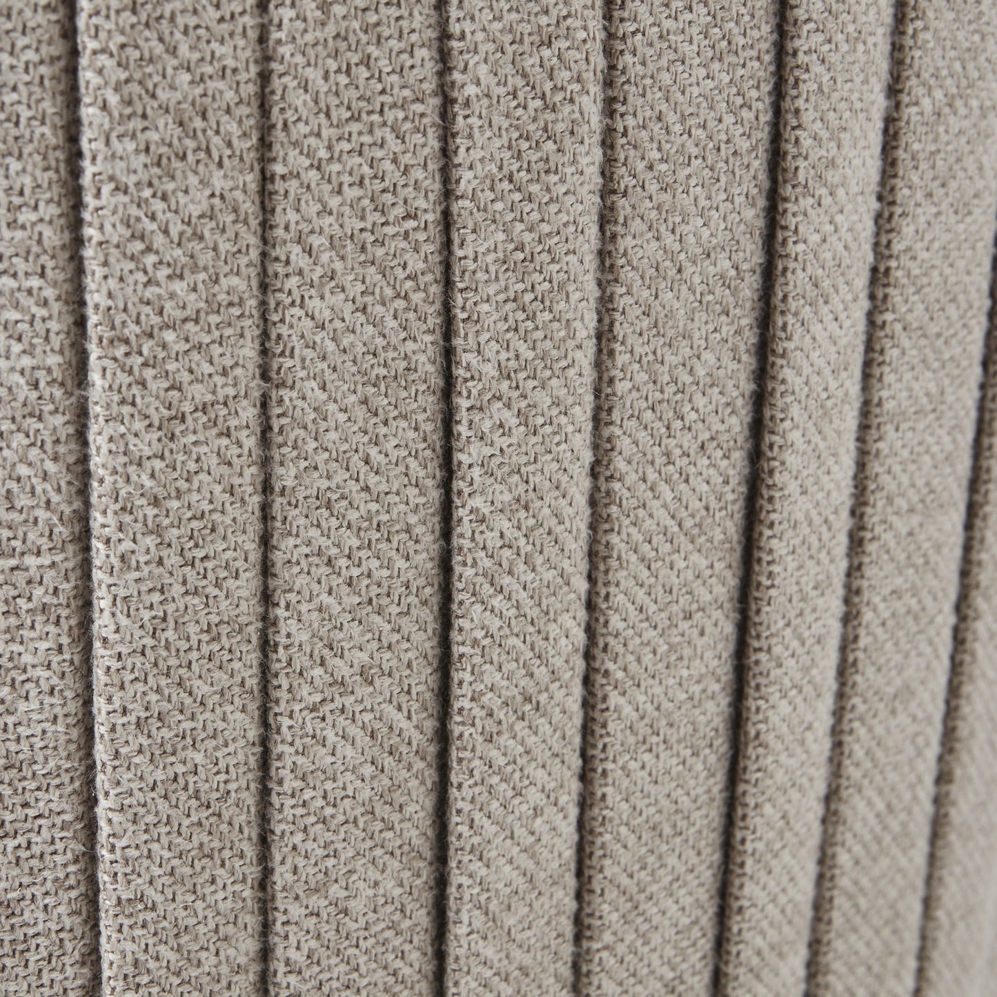 Close-up of textured beige fabric with a ribbed pattern