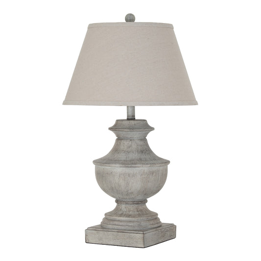 Table lamp with a textured base and beige shade on a white background