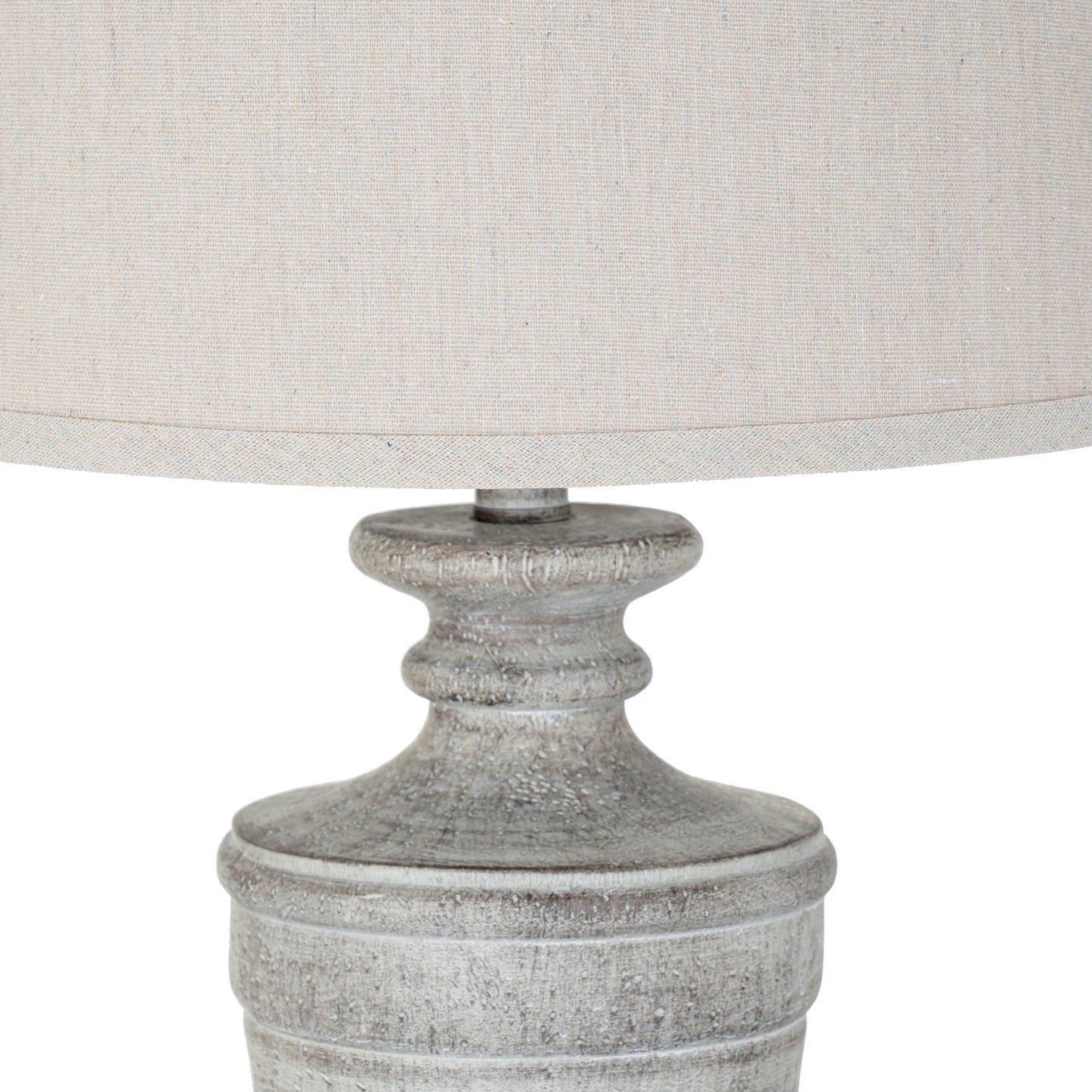 Close-up of a textured lamp base with a light gray shade on a white background
