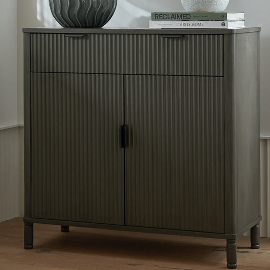Dark wooden cabinet with ribbed texture on a wooden floor.