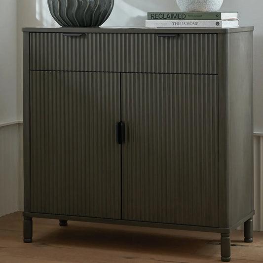 Dark wooden cabinet with ribbed texture on a wooden floor.