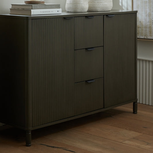 Dark wooden sideboard with drawers on a wooden floor