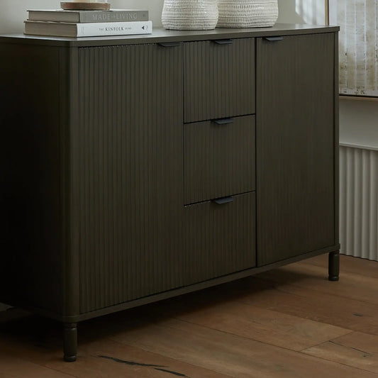 Dark wooden sideboard with drawers on a wooden floor
