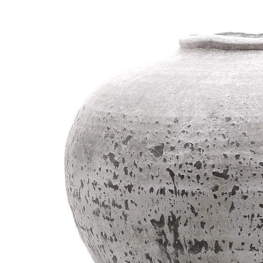 Close-up of a textured gray ceramic jar on a white background