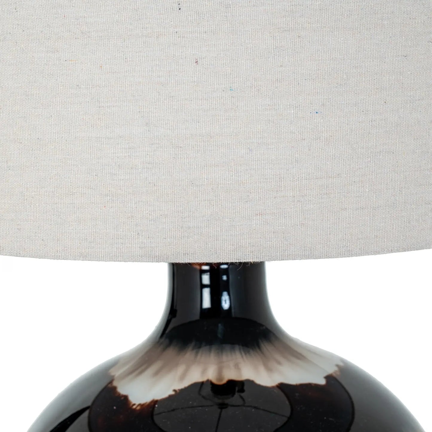 Close-up of a lamp with a textured gray shade and dark base.
