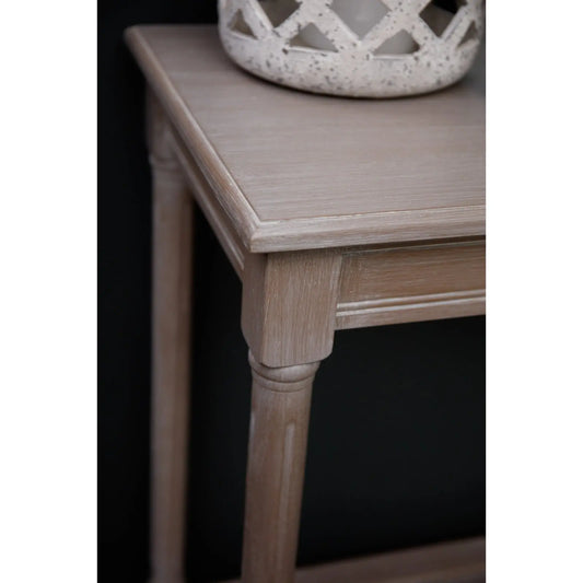 Wooden side table with a decorative item on top against a black background