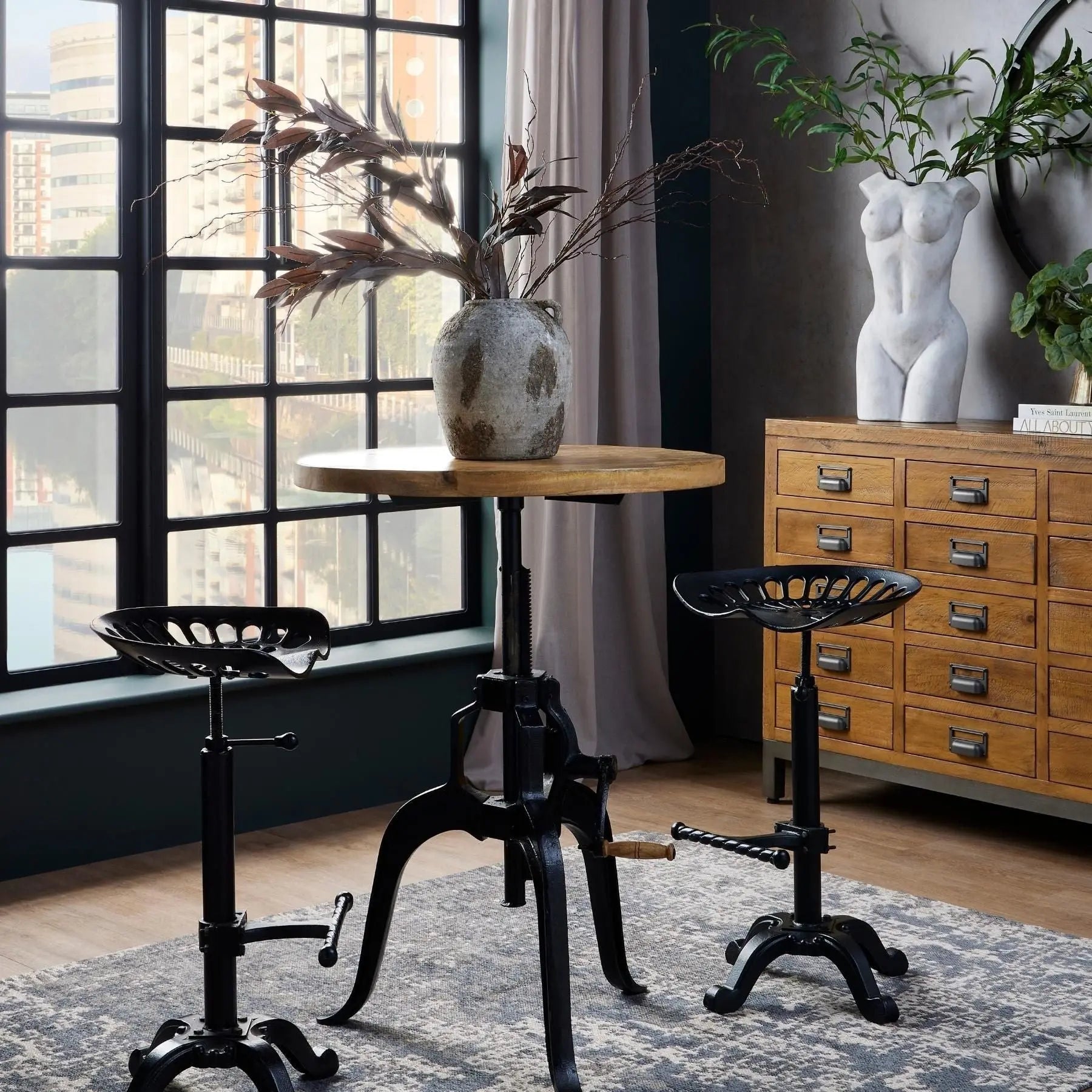 Modern interior with a wooden table, black stools, and decorative elements.