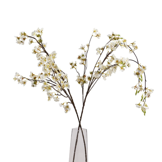 Artificial white flowers in a clear vase on a white background