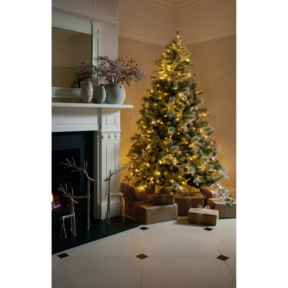 Decorated Christmas tree in a living room with a fireplace and presents underneath.