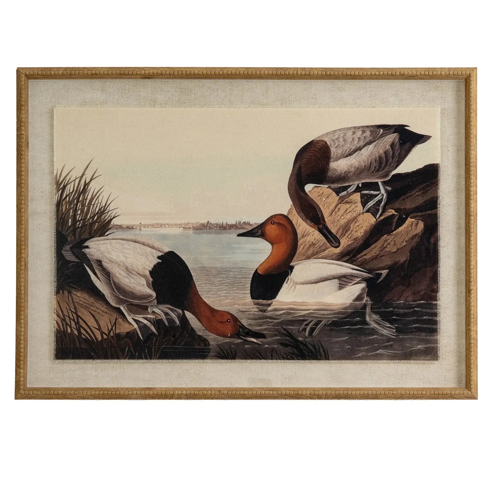 Framed artwork of ducks by a lake with a gold frame.