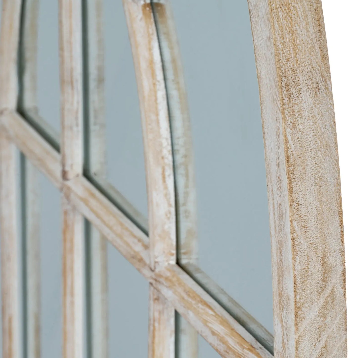 Close-up of a wooden mirror with geometric design on a light background