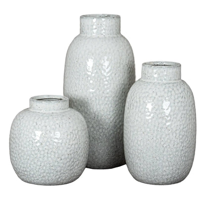 Three textured white vases of different sizes on a white background
