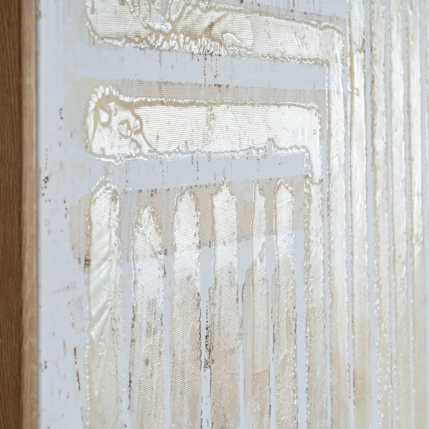Abstract artwork with white and beige tones on a textured surface