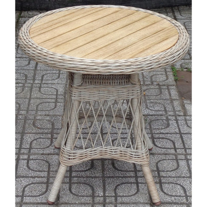Round wicker table with wooden top on a patterned pavement