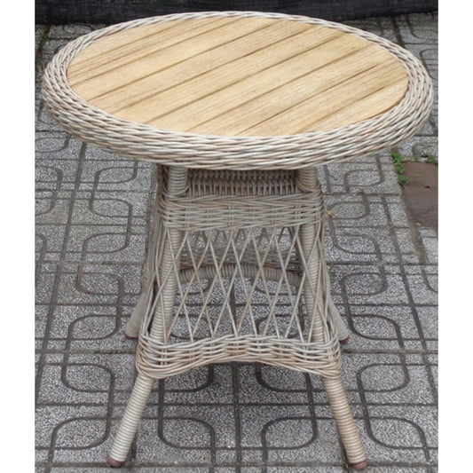 Round wicker table with wooden top on a patterned pavement
