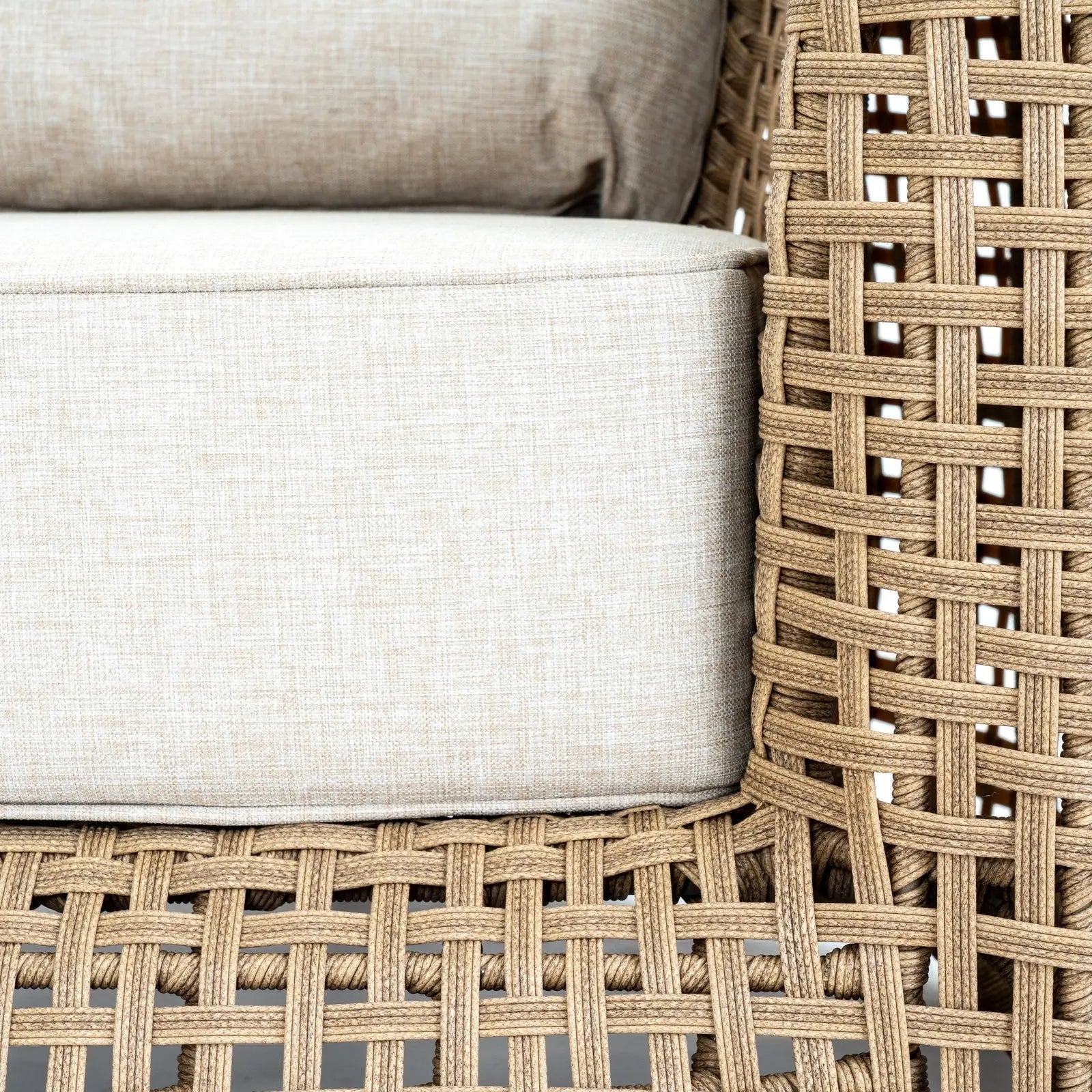 Close-up of woven chair with beige cushions