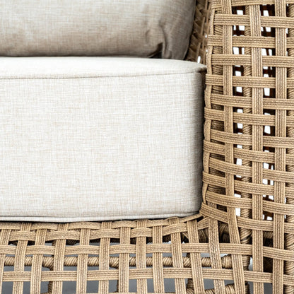 Close-up of woven chair with beige cushions