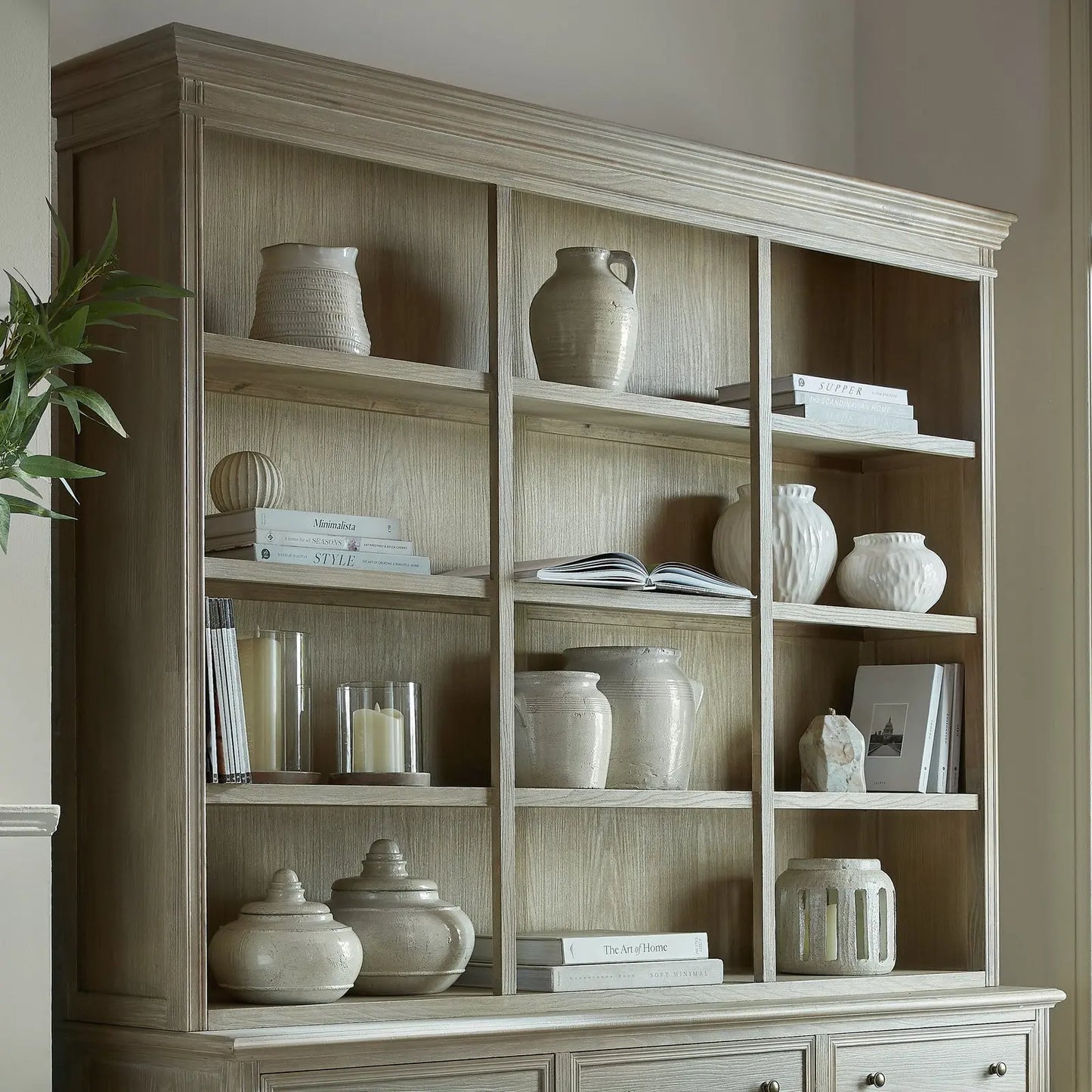 Wooden bookshelf with decorative items against a neutral wall