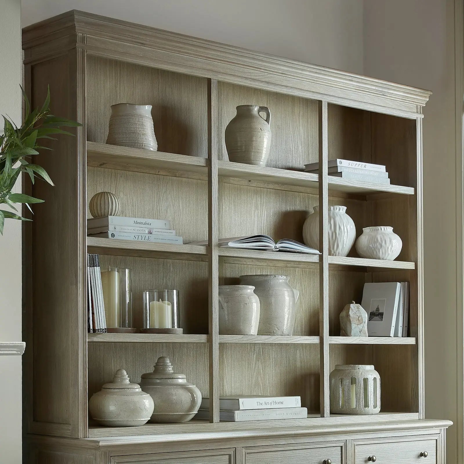 Wooden bookshelf with decorative items against a neutral wall