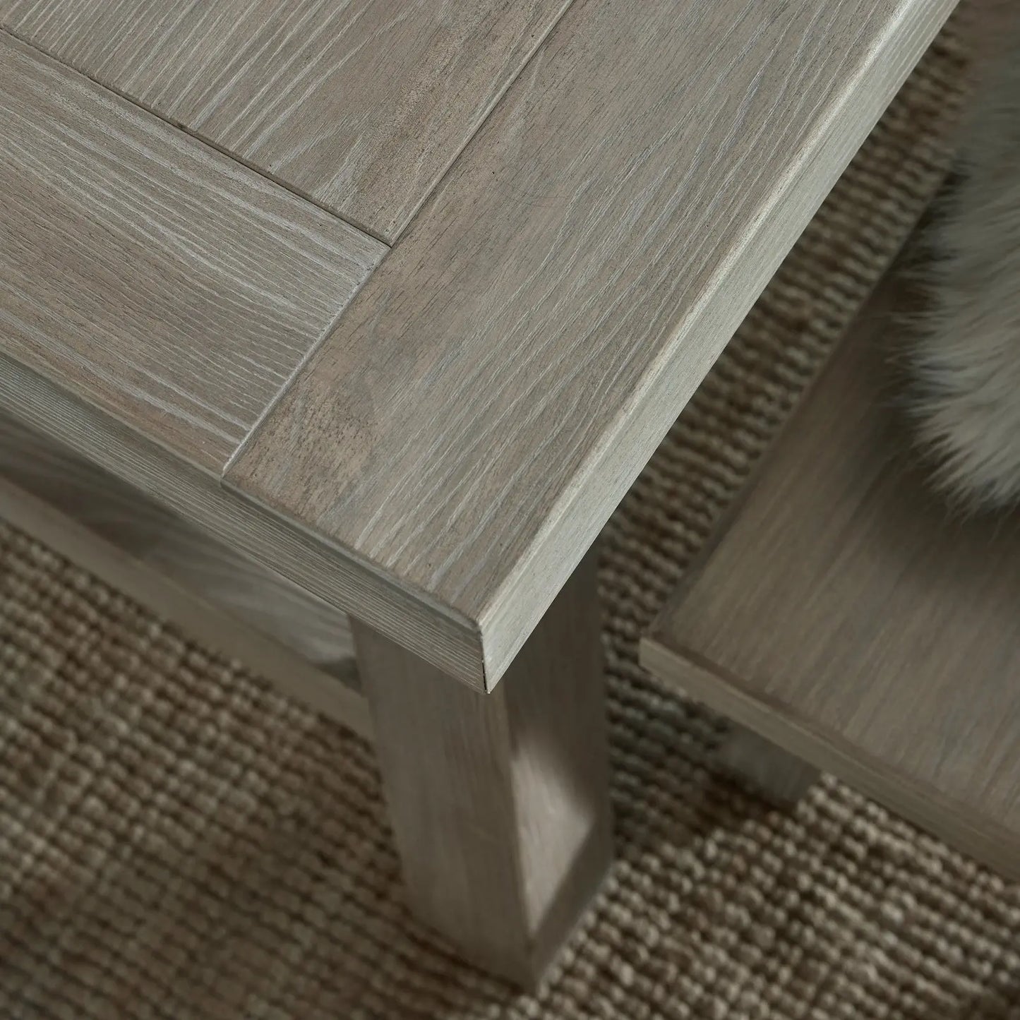 Close-up of a wooden table corner on a textured surface