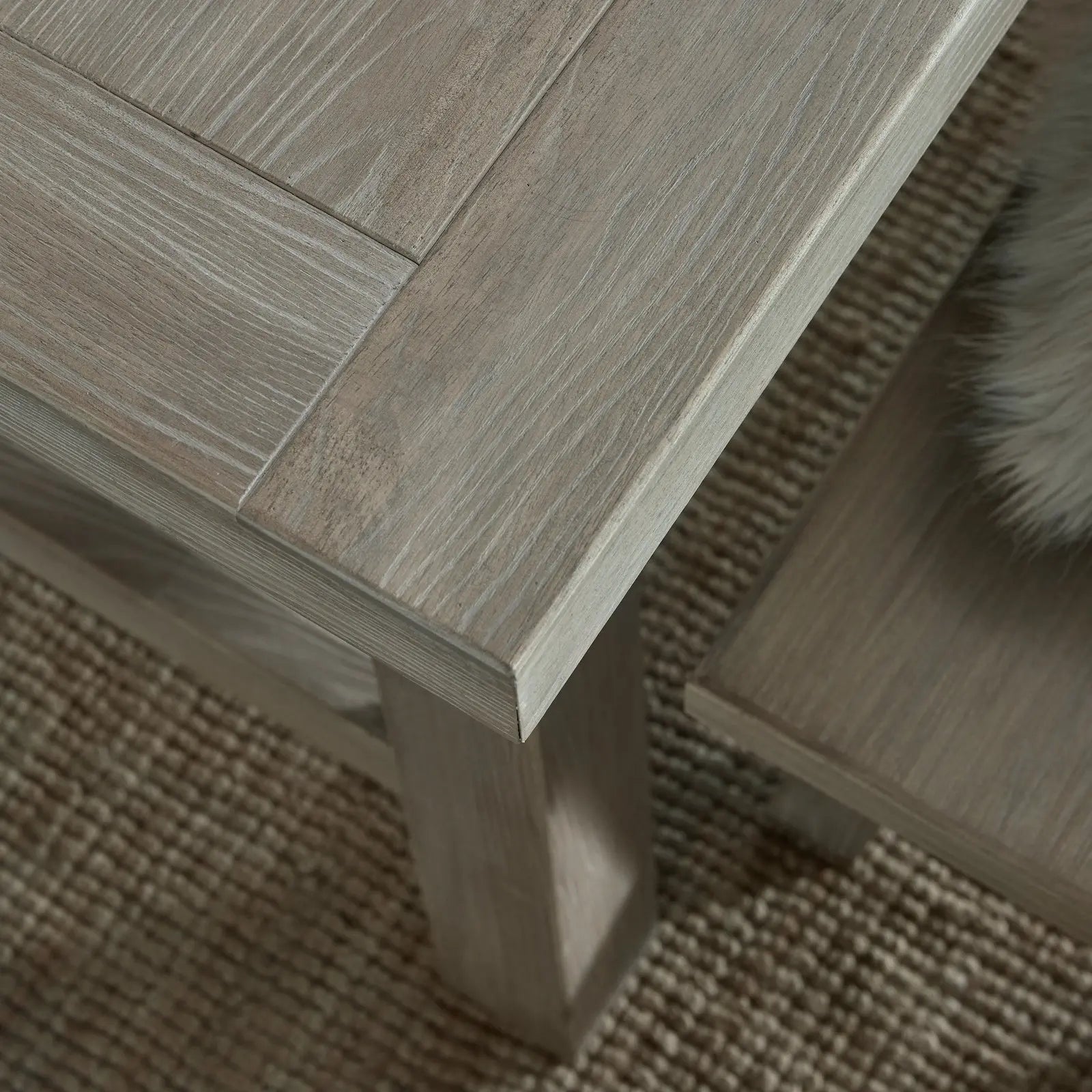 Close-up of a wooden table corner on a textured surface