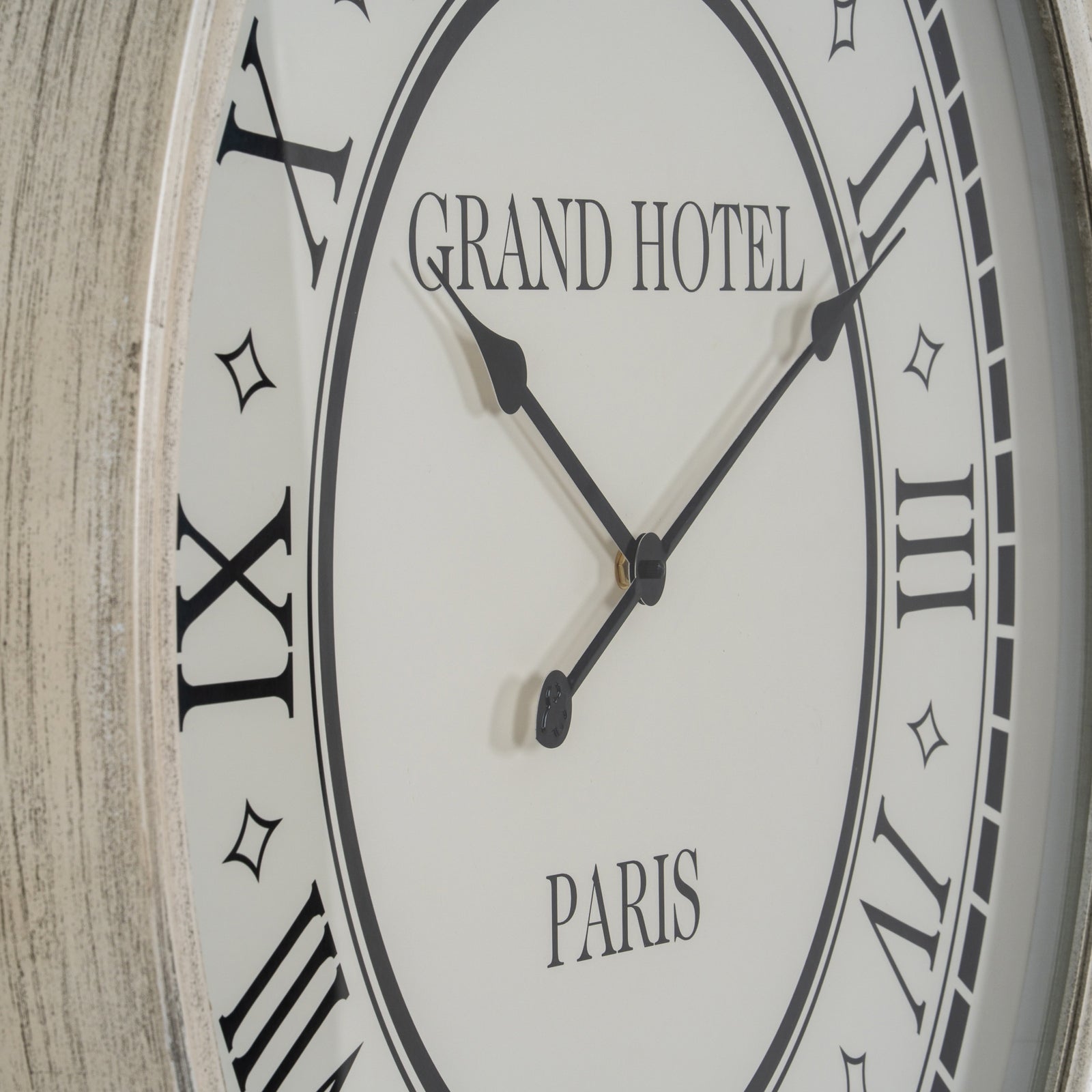 Wall clock with 'Grand Hotel Paris' text on a wooden background