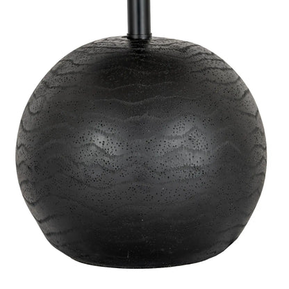 Black spherical object with textured surface on a white background