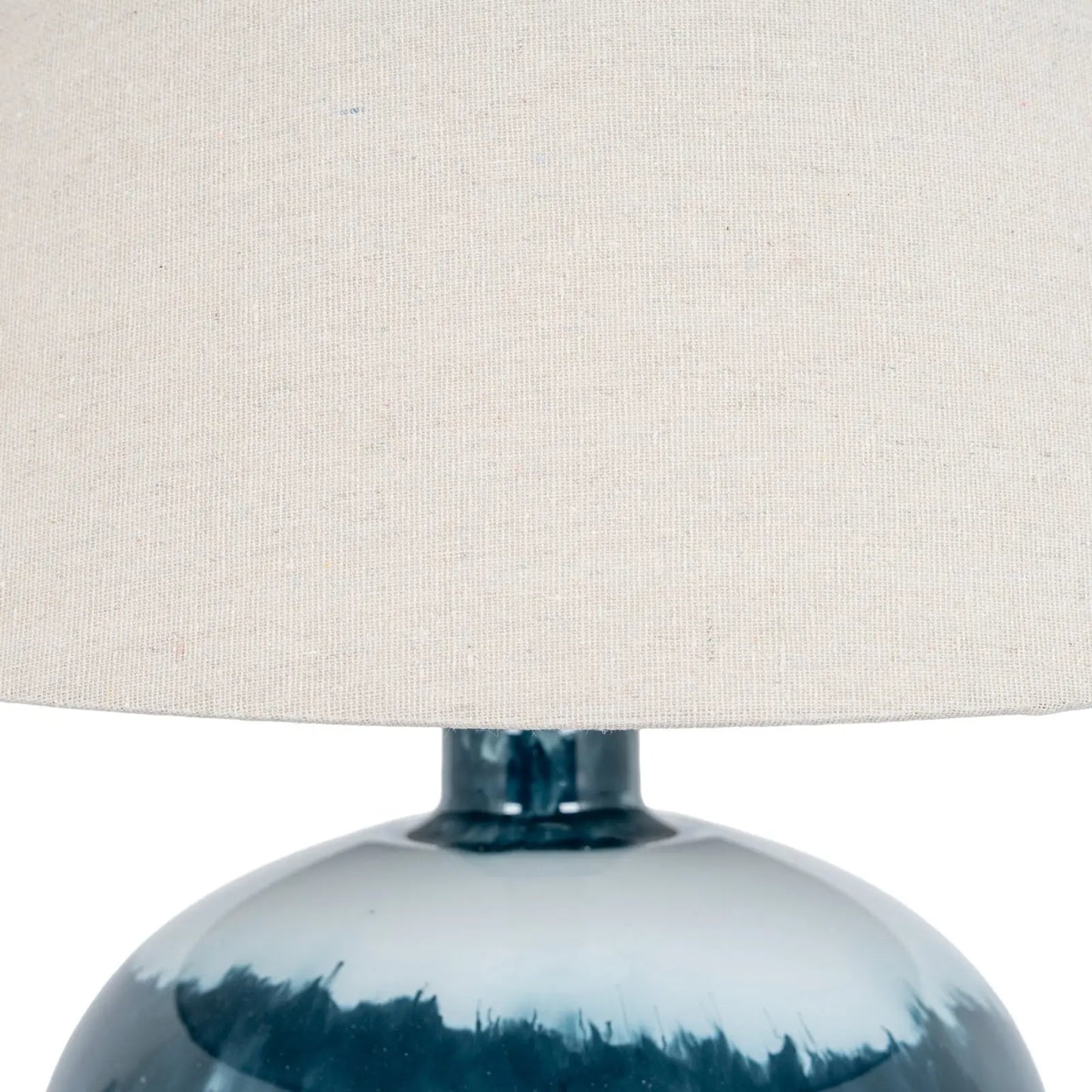 Close-up of a lamp with a blue base and beige lampshade on a white background
