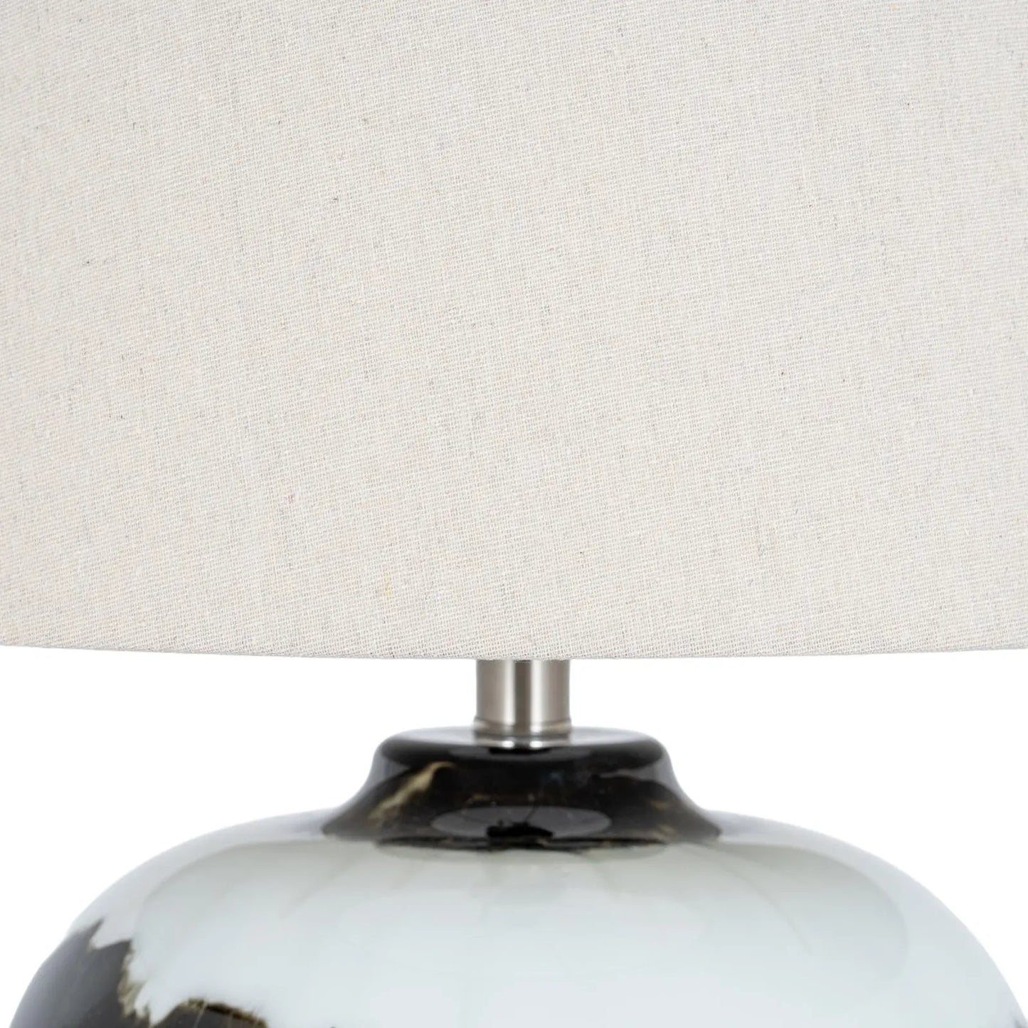 Close-up of a lamp with a white shade and black and white base.