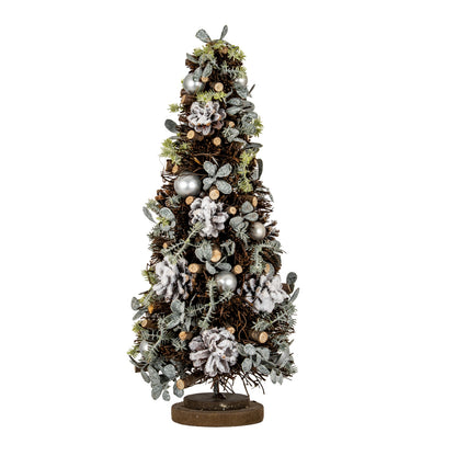 A decorative artificial Christmas tree with a rustic brown trunk and base, decorated with silver metallic ornaments, white frosted pinecones, green pine needles, and brown pinecones, isolated on a white background.