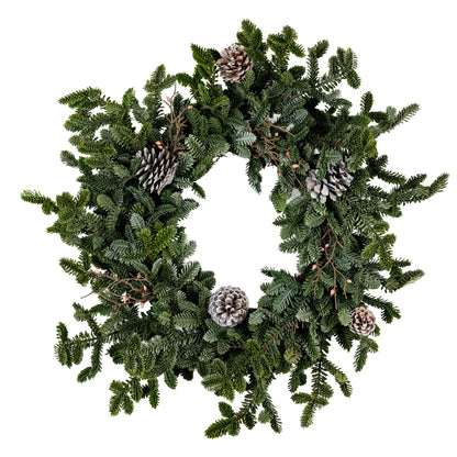 Green Christmas wreath with pine cones on a white background