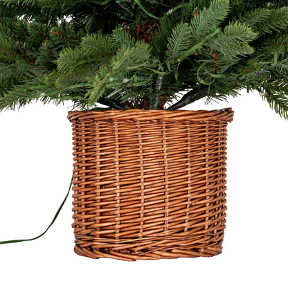 Wicker basket under a Christmas tree on a white background