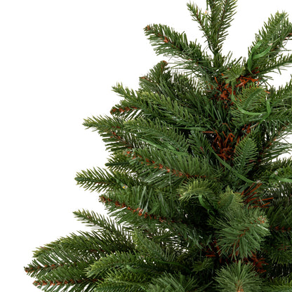 Close-up of a green artificial Christmas tree with brown accents on a white background