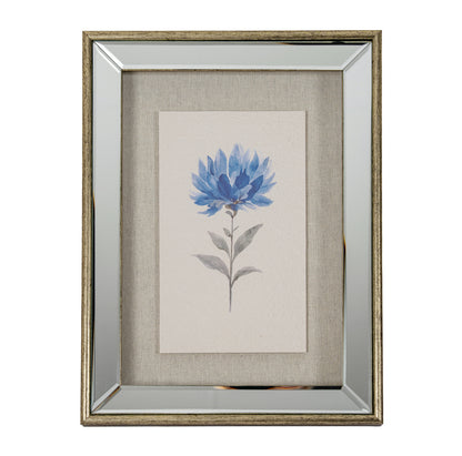 A framed botanical art print featuring a blue flower with gray-green leaves on a textured beige linen background, enclosed in a distressed silver frame.