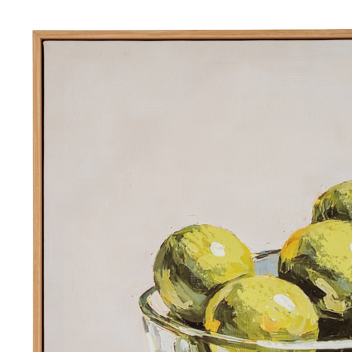 A framed still life painting showing yellow-green lemons in a glass bowl against a warm off-white background, with a light wood frame visible on the left and top edges.