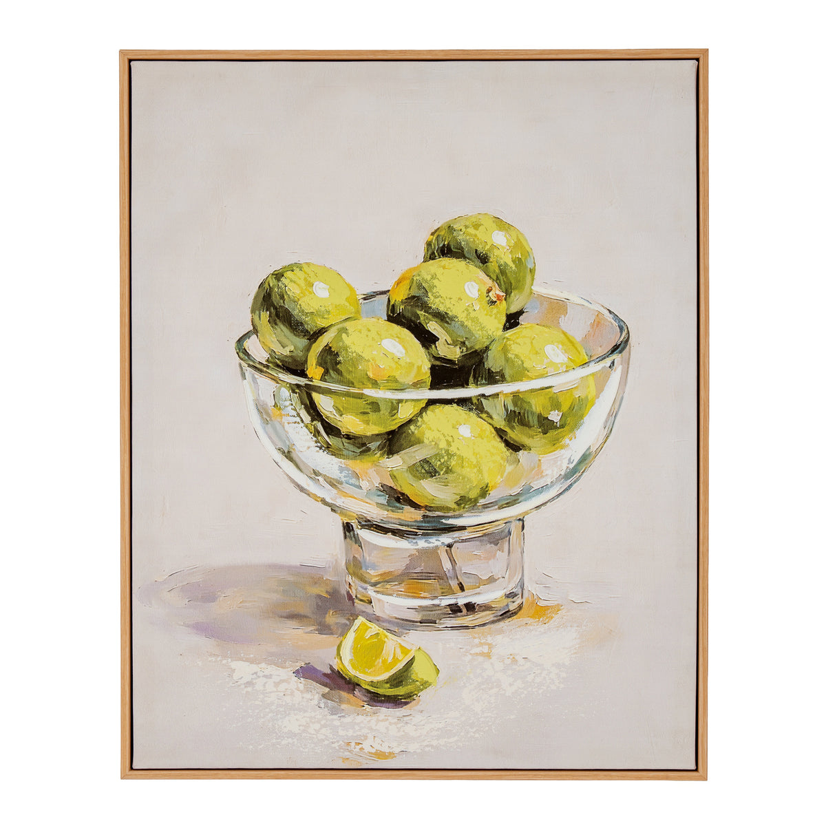 A framed still life painting depicting green limes in a clear glass bowl with a lime wedge on a light neutral background, enclosed in a thin light wood frame.