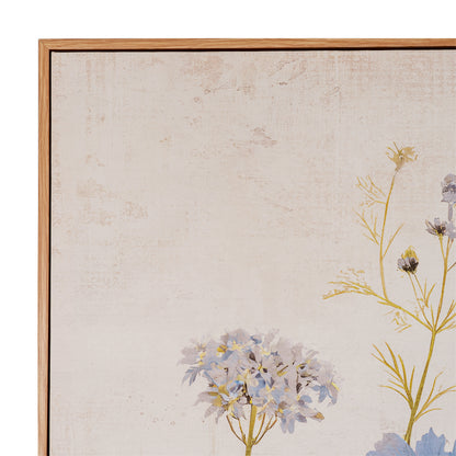 Close-up of a framed floral artwork showing pale blue and lavender flowers with yellow-green stems on a textured off-white background, bordered by a light wood frame.